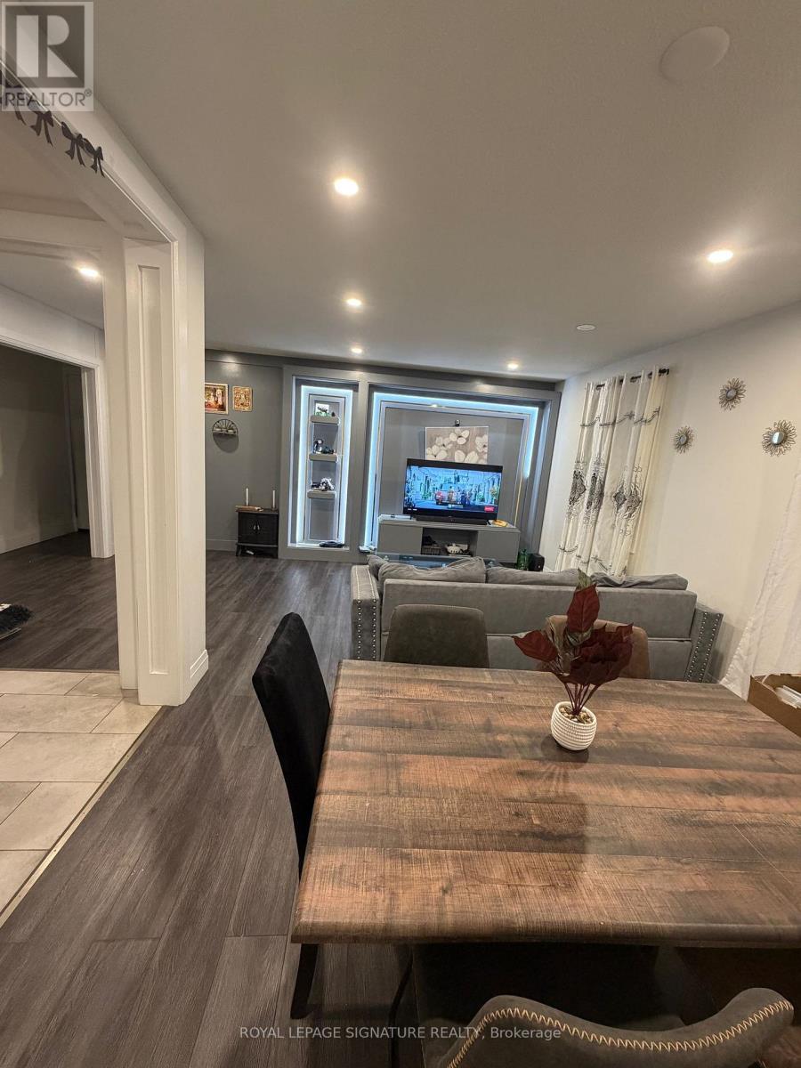A living room with a wooden table and a television on the wall.