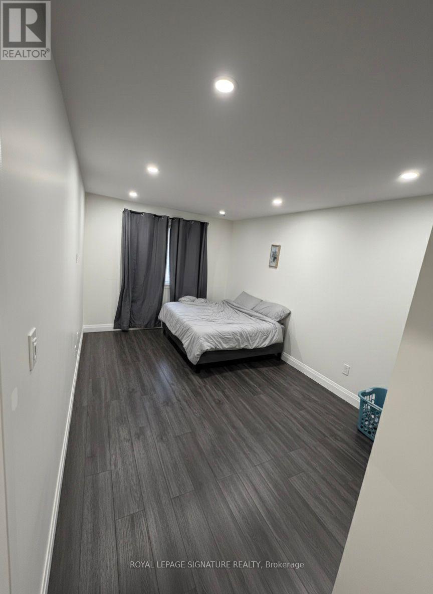 A bedroom with a bed and a basket on the floor.