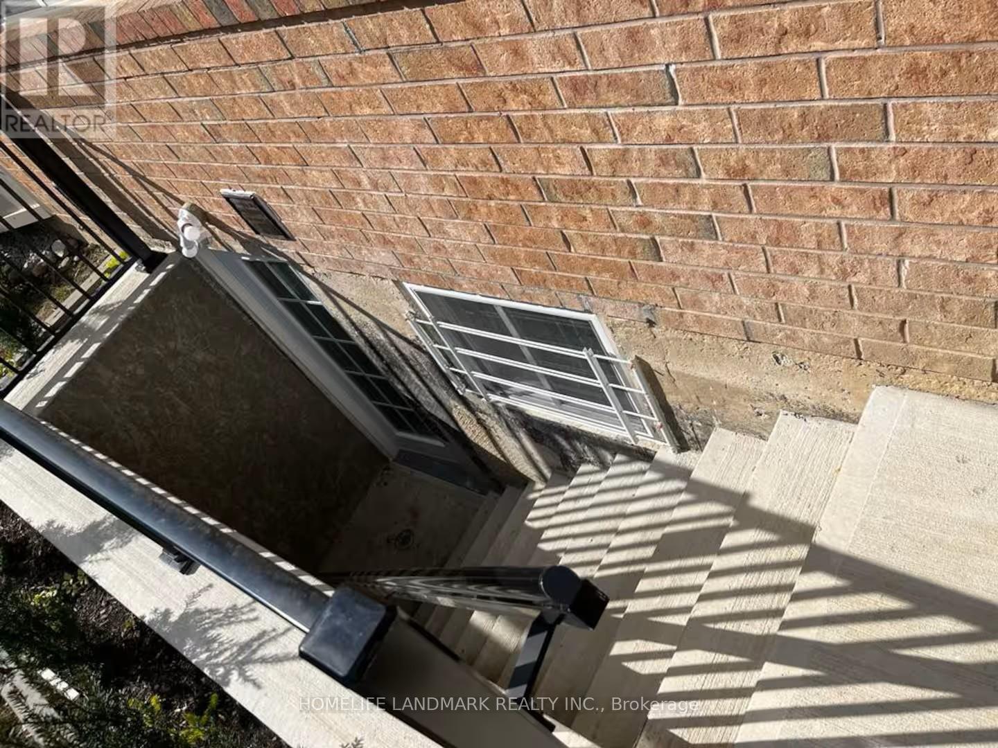 A broken window on a building with a brick wall.