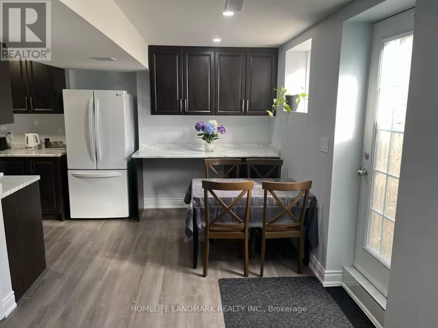 A kitchen with a table and chairs in front of it.