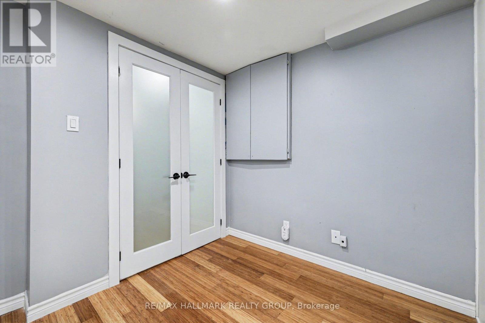 A room with a door and a cabinet on the wall.