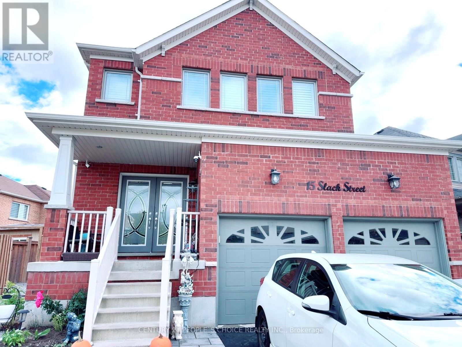 A red brick house with a white car parked in front.