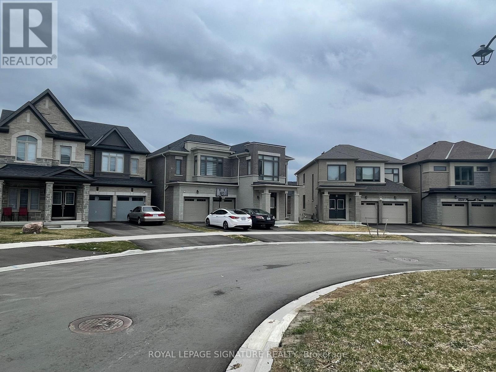 A row of houses with cars parked in front of them.