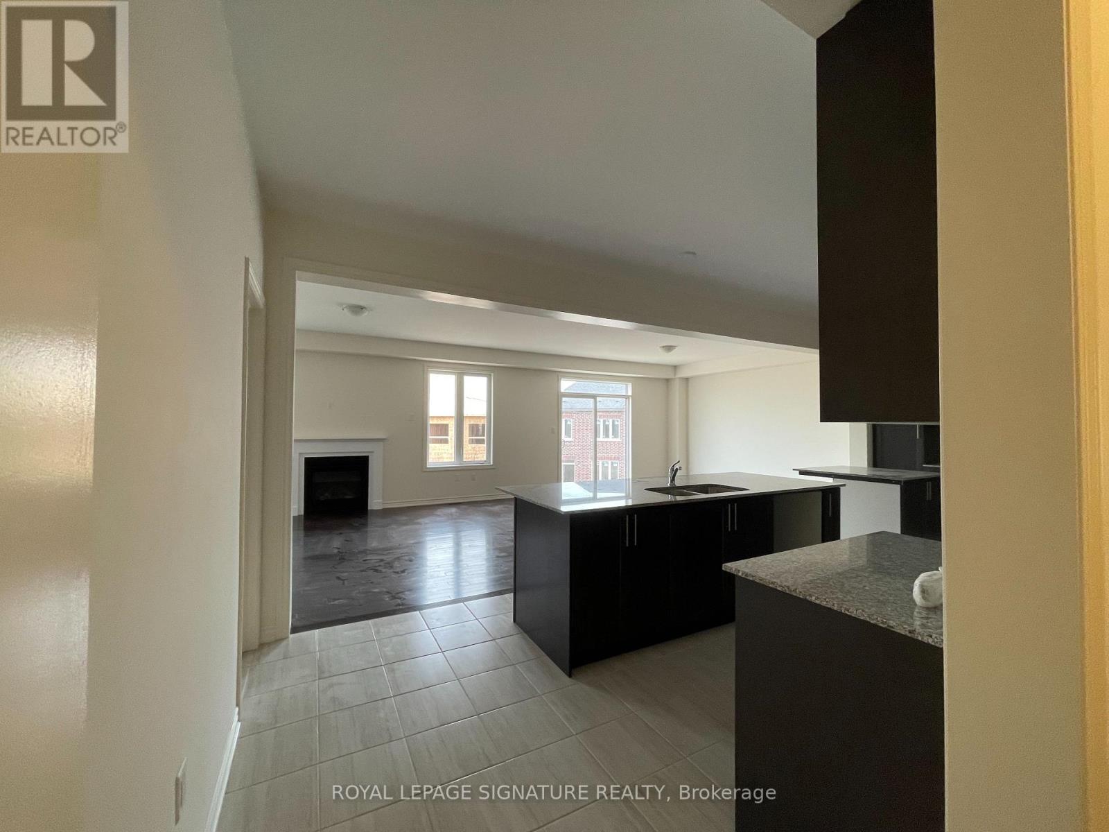 A spacious kitchen with black cabinets and a large island.