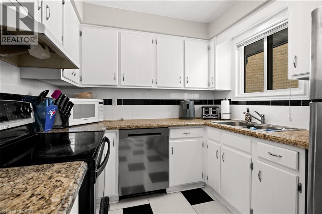 A kitchen with white cabinets and a granite countertop.