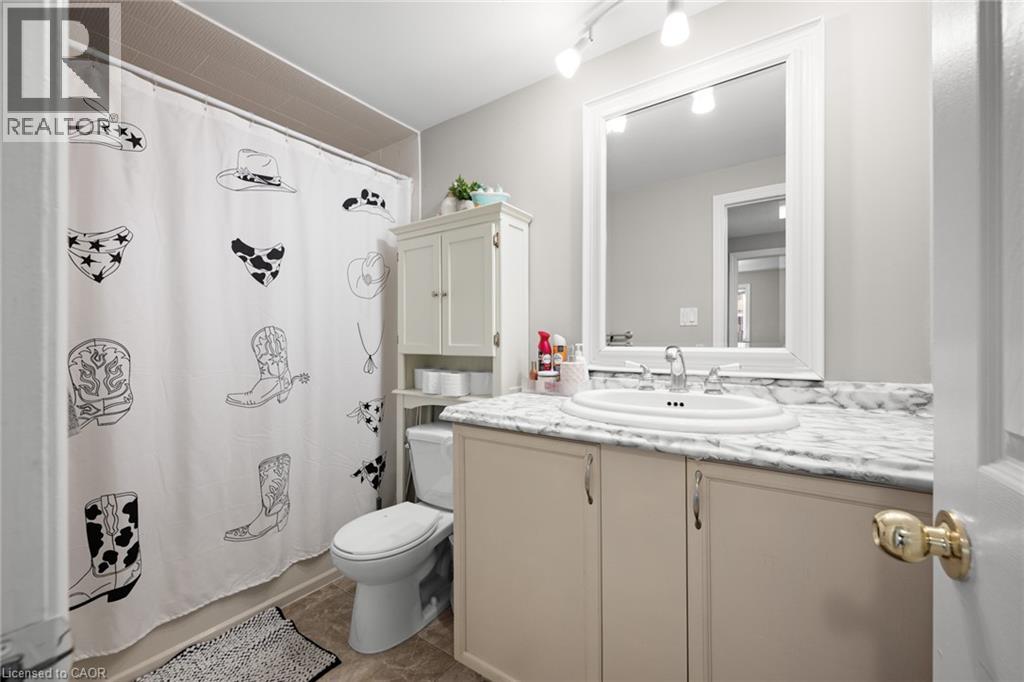 A realtor photo of a bedroom with a bed, a desk, and a chair.