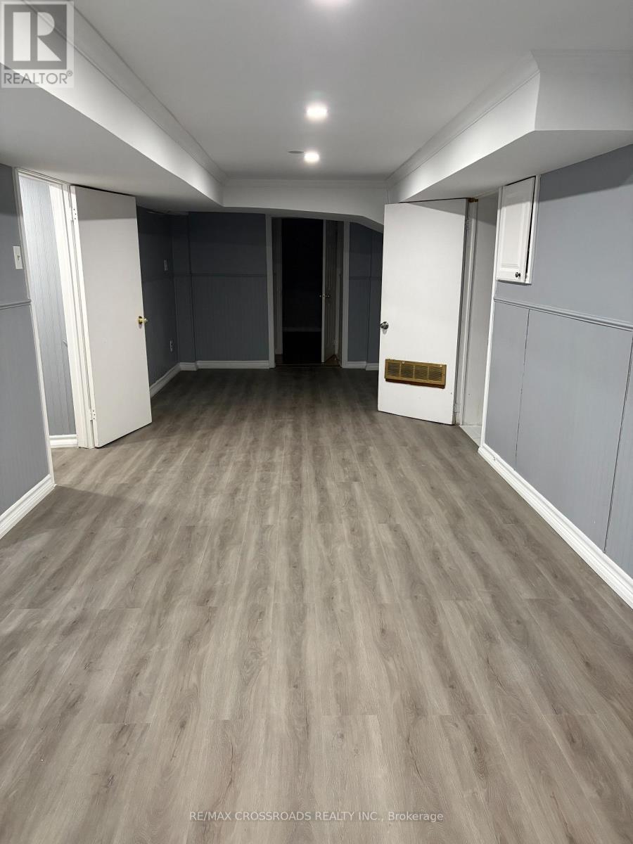 A spacious room with grey walls and wooden flooring.