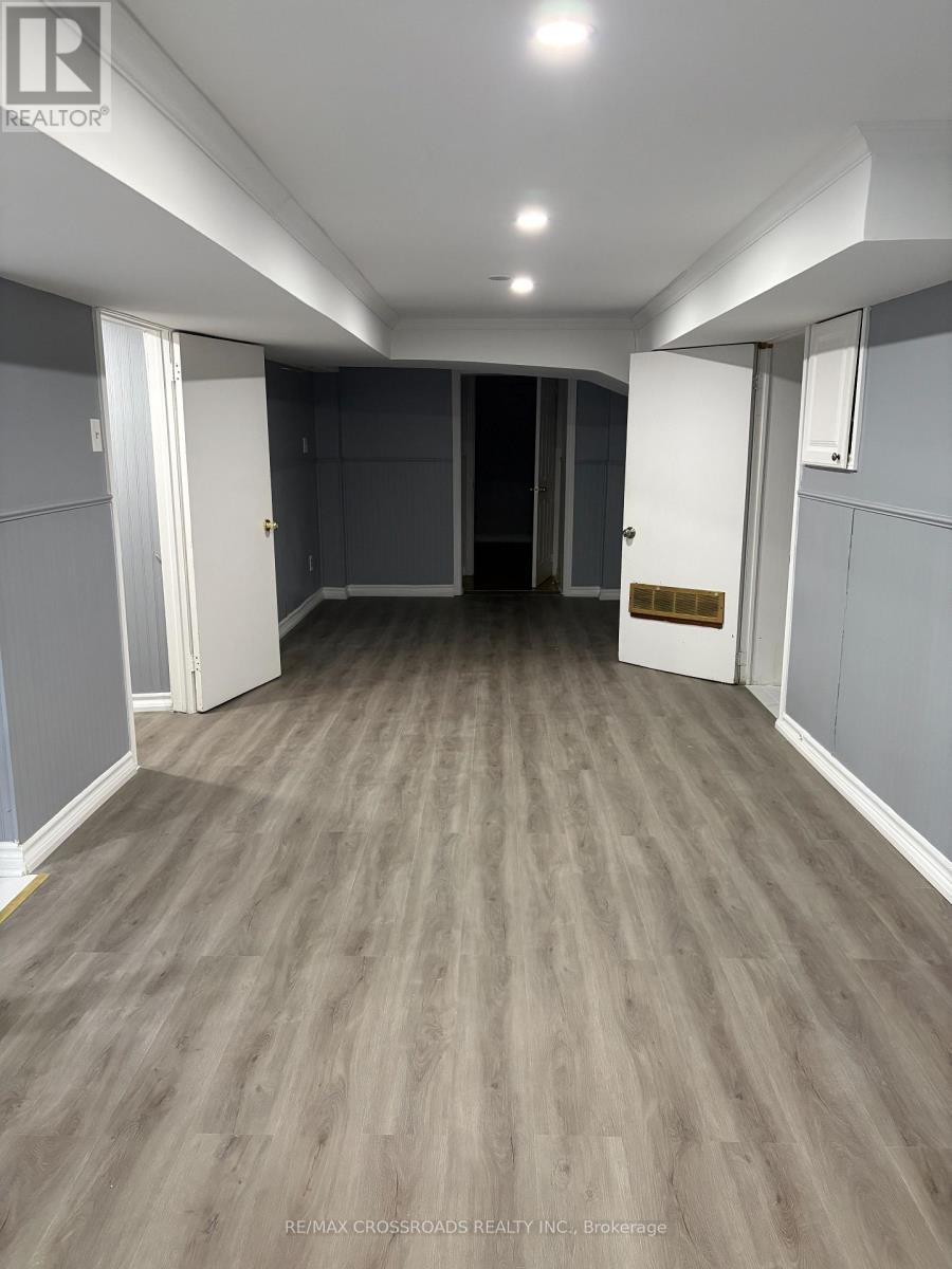 A long hallway with wood flooring and white walls.