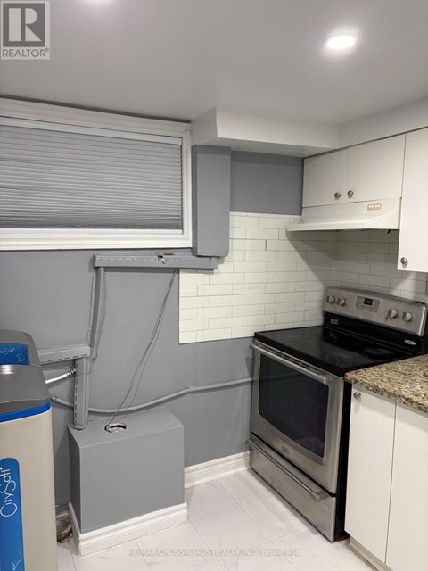 A kitchen with a stove top oven and a range hood.