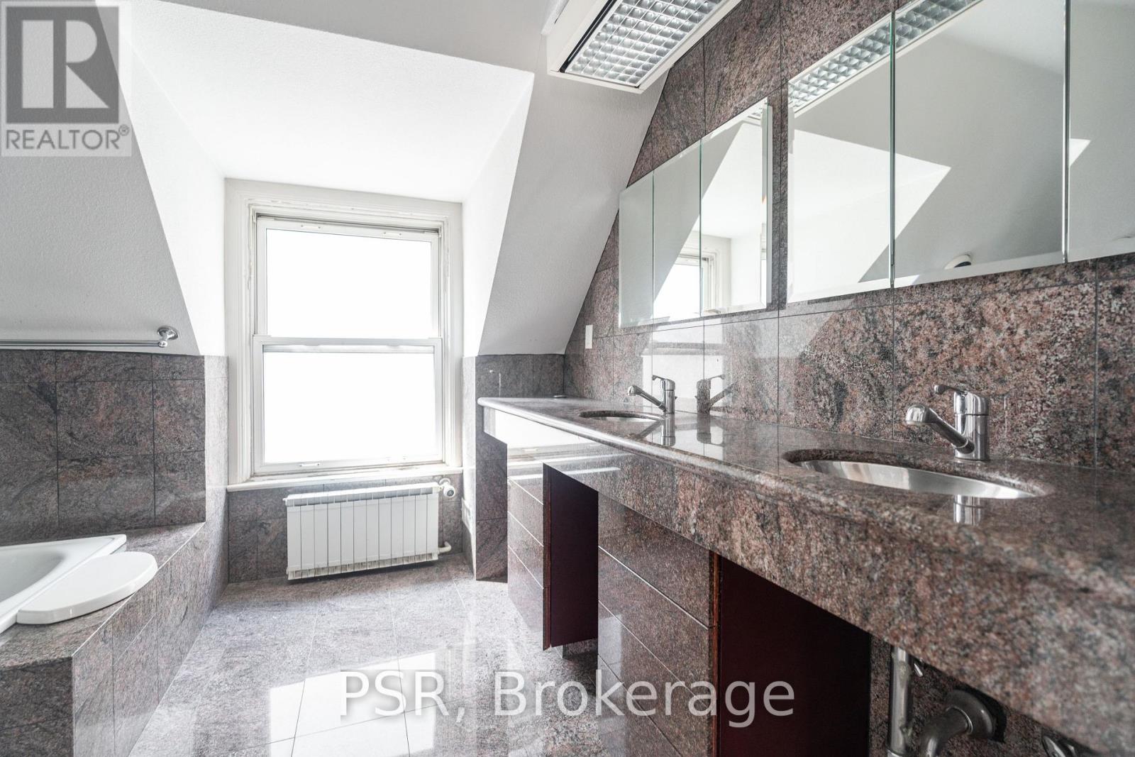 A bathroom with a large mirror and a window.