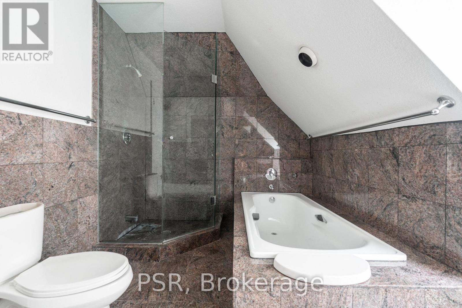 A bathroom with a toilet, a bathtub and a shower.