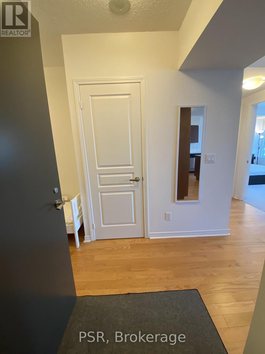 A hallway with a door and a mat on the floor that says PSR Brokerage.