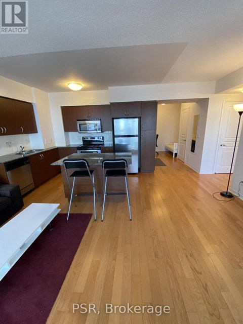 A kitchen with wooden floors and a dining table with chairs.