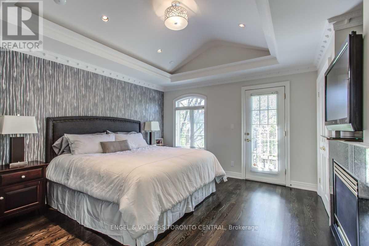 A bedroom with a large bed and a flat screen TV mounted on the wall.