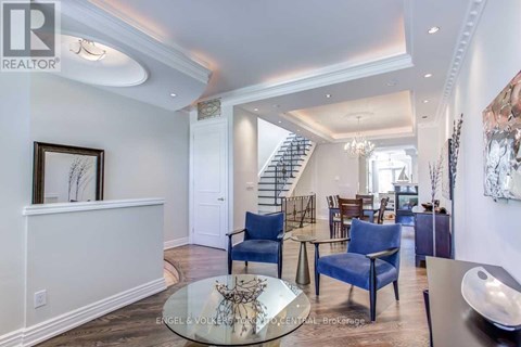 A living room with a glass table and blue chairs.