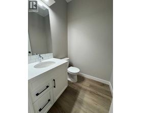 A bathroom with a white sink and toilet.