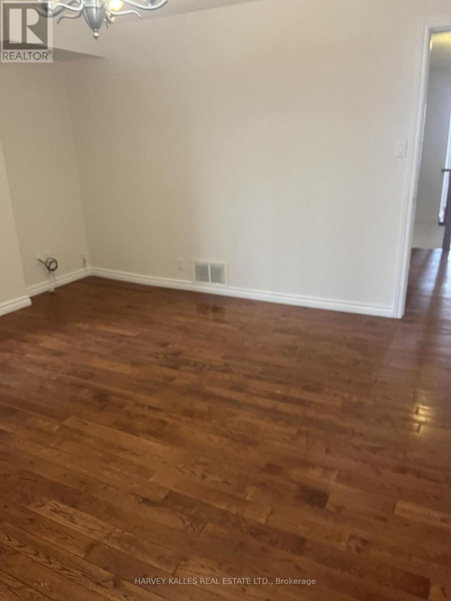 A room with wooden flooring and white walls.