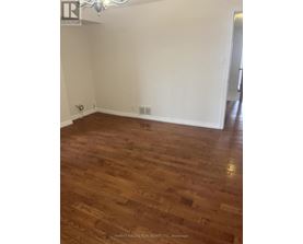 A room with wooden flooring and white walls.