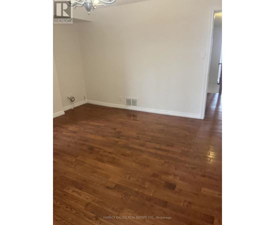 A room with wooden flooring and white walls.