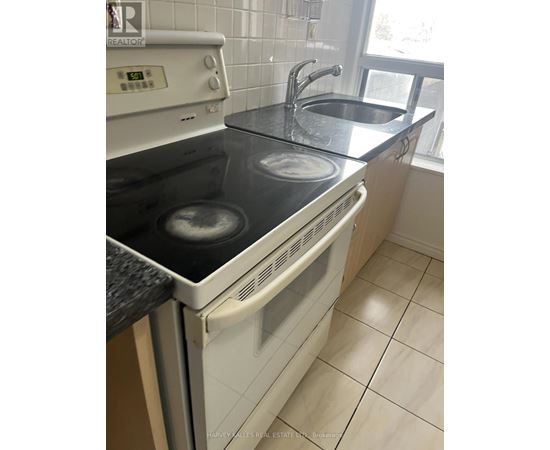 A white oven with a black stove top is in a kitchen.