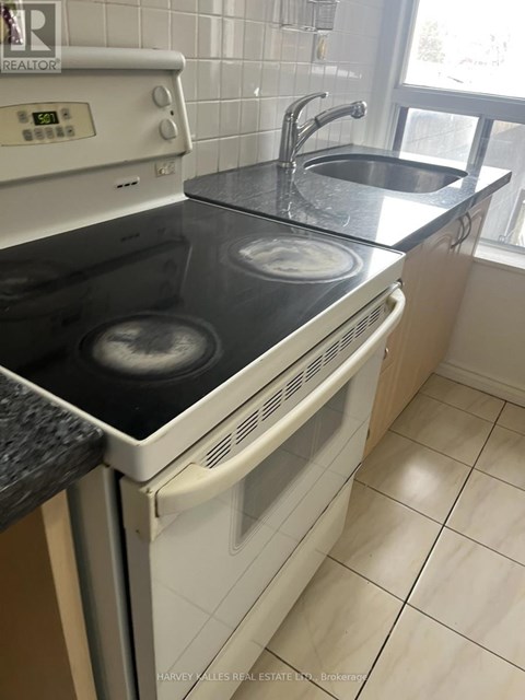 A white oven with a black stove top is in a kitchen.