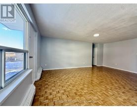 A room with wooden flooring and a window showing a snowy scene outside.