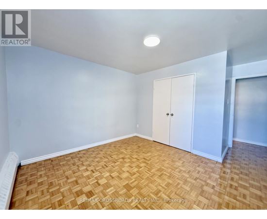 A room with wooden flooring and a window showing a snowy scene outside.