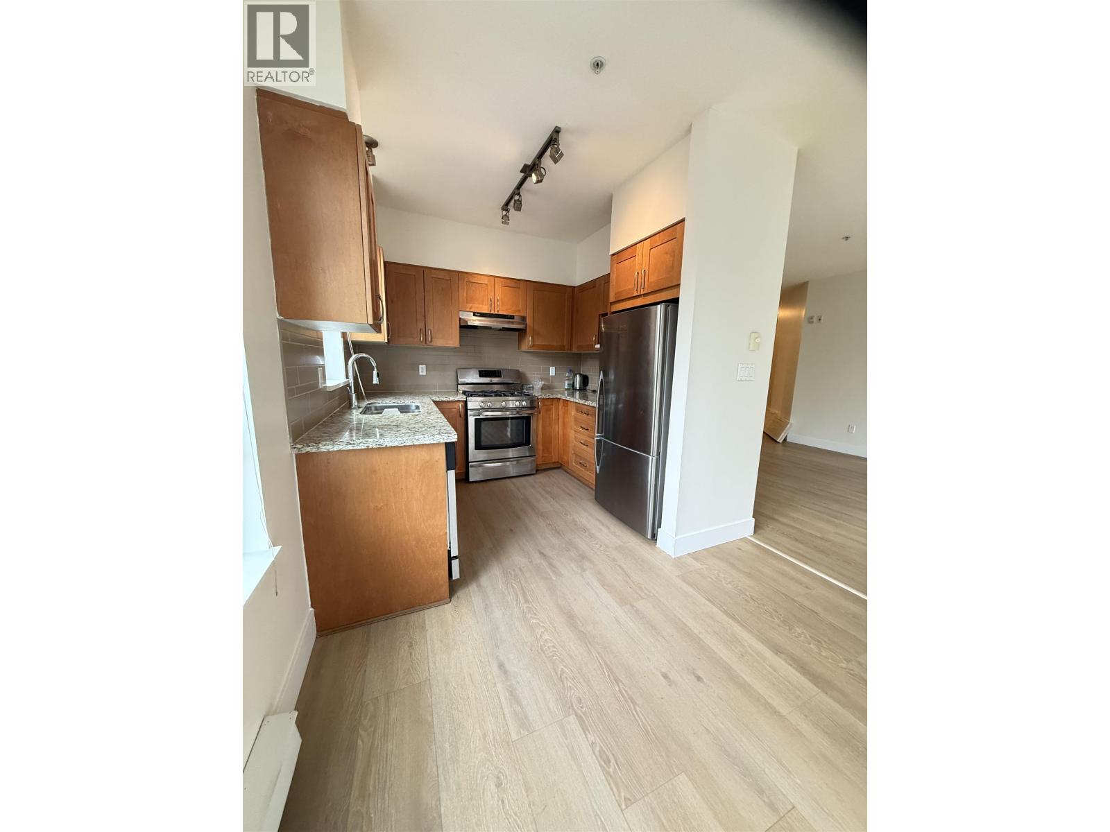 A kitchen with wooden cabinets and a refrigerator.