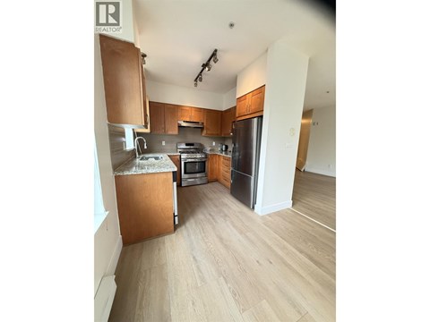 A kitchen with wooden cabinets and a refrigerator.