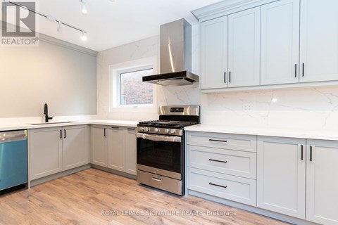 A kitchen with white cabinets and a stove top oven.