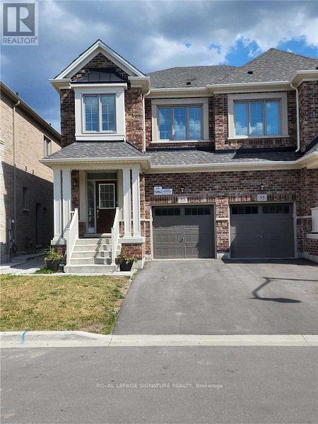 A two-story brick house with a garage and a driveway in front.