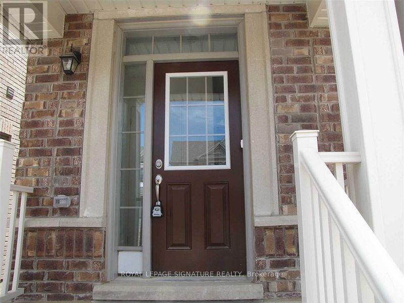 A brown door with a glass window and a key in the lock.