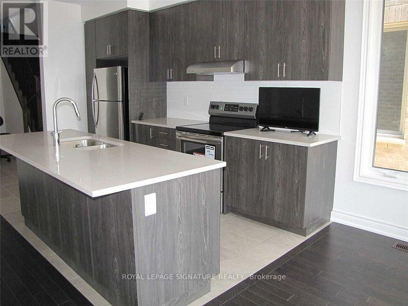 A modern kitchen with a sink, stove, and cabinets.