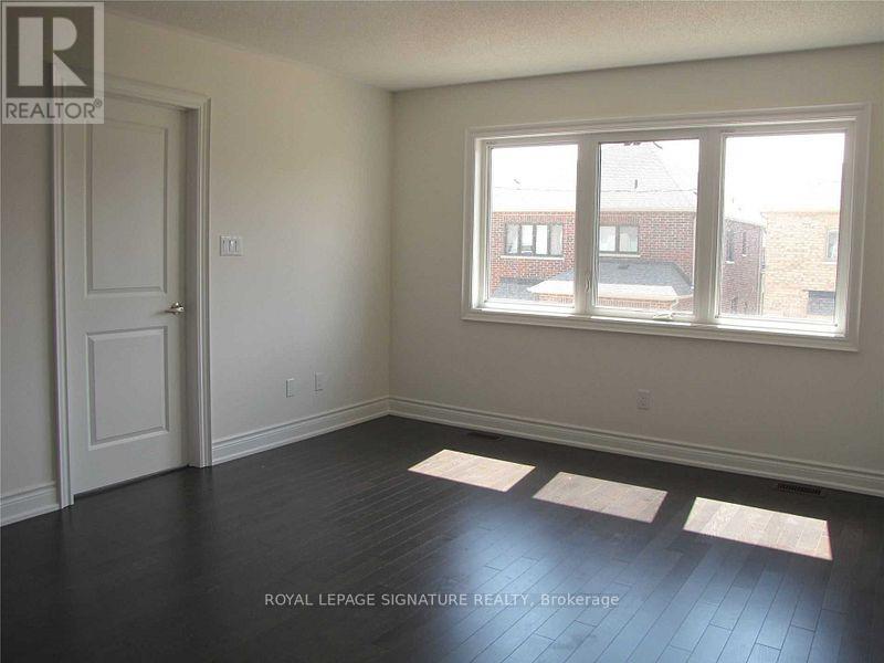 A room with a door and a window with a view of buildings outside.