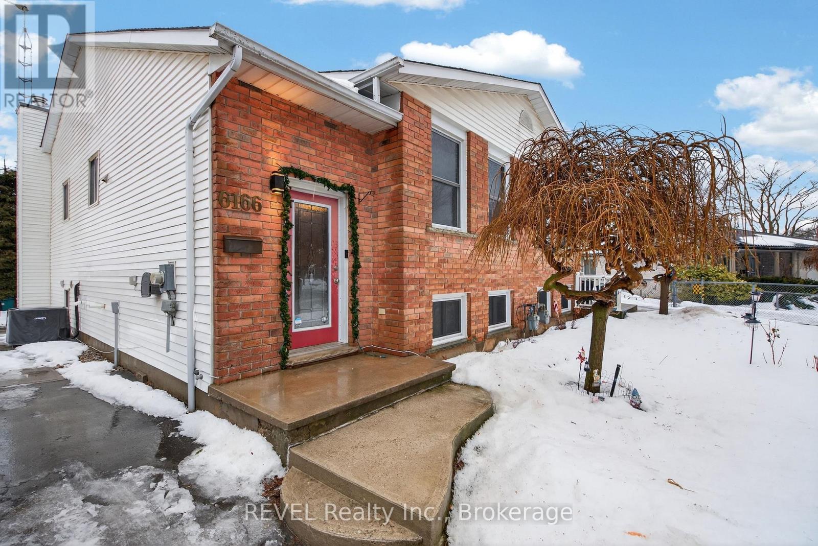 A house with a red door and a snow-covered ground.