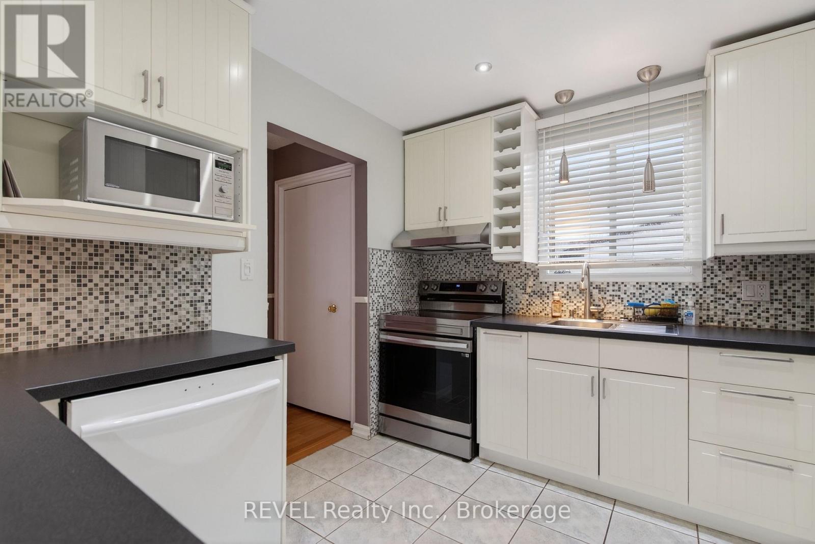 A kitchen with white cabinets and a black countertop.