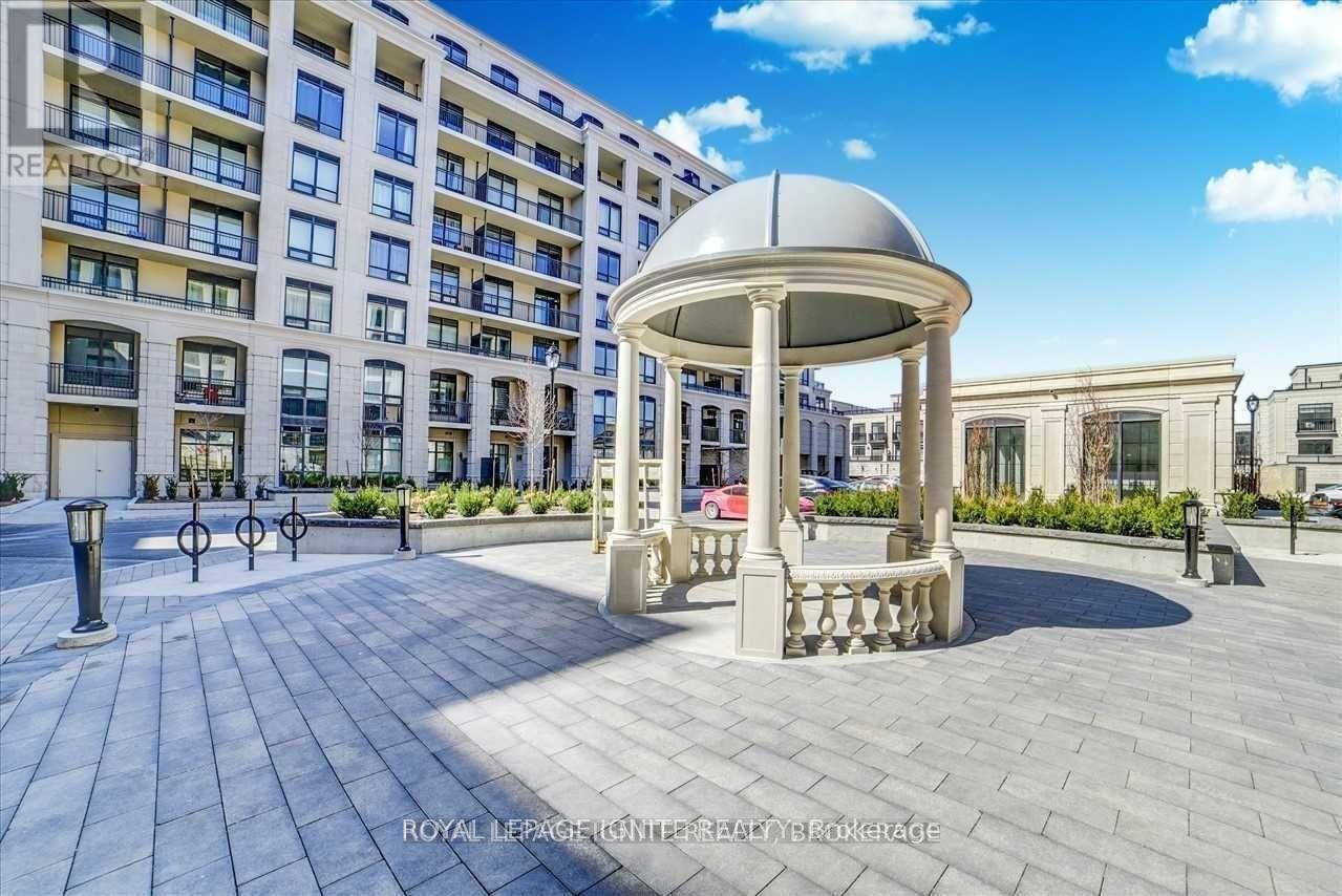 A gazebo-like structure sits in the middle of a paved courtyard.