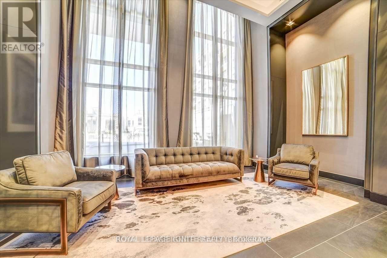 A living room with a large window and a rug on the floor.