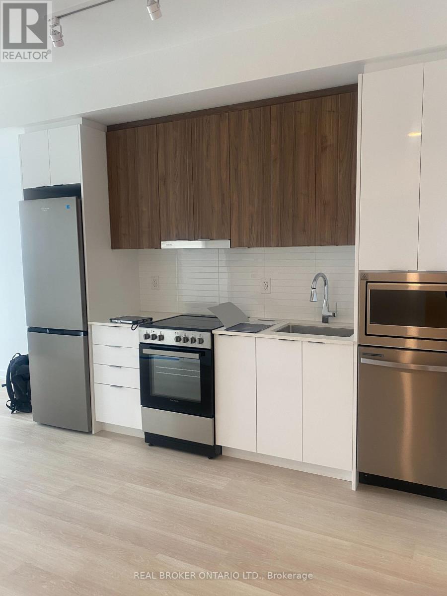 A modern kitchen with white cabinets and stainless steel appliances.