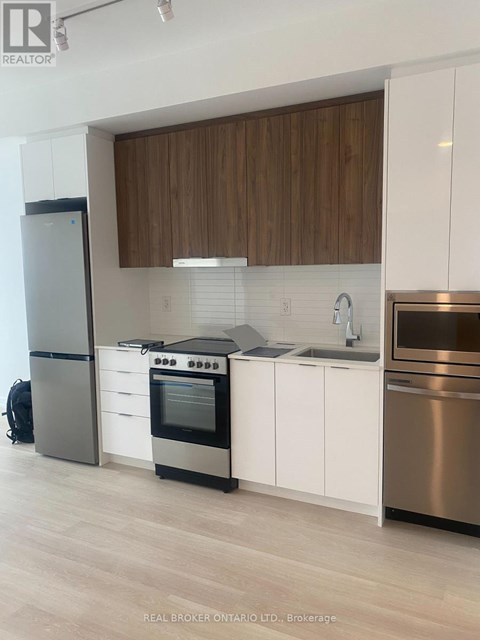 A modern kitchen with white cabinets and stainless steel appliances.