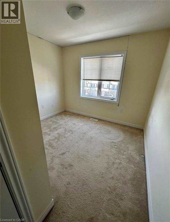 A bedroom with a carpeted floor and a window.