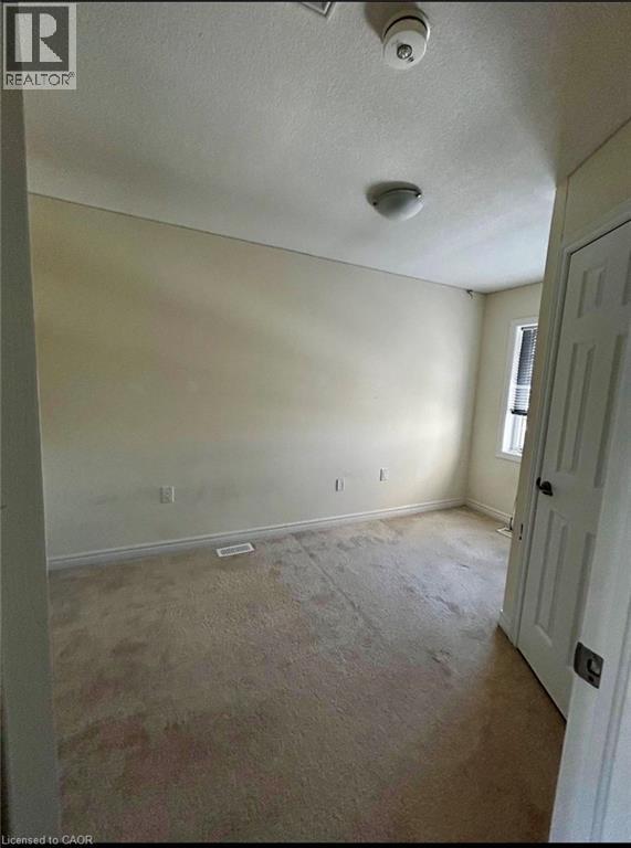 A room with a carpeted floor and a door on the right side.