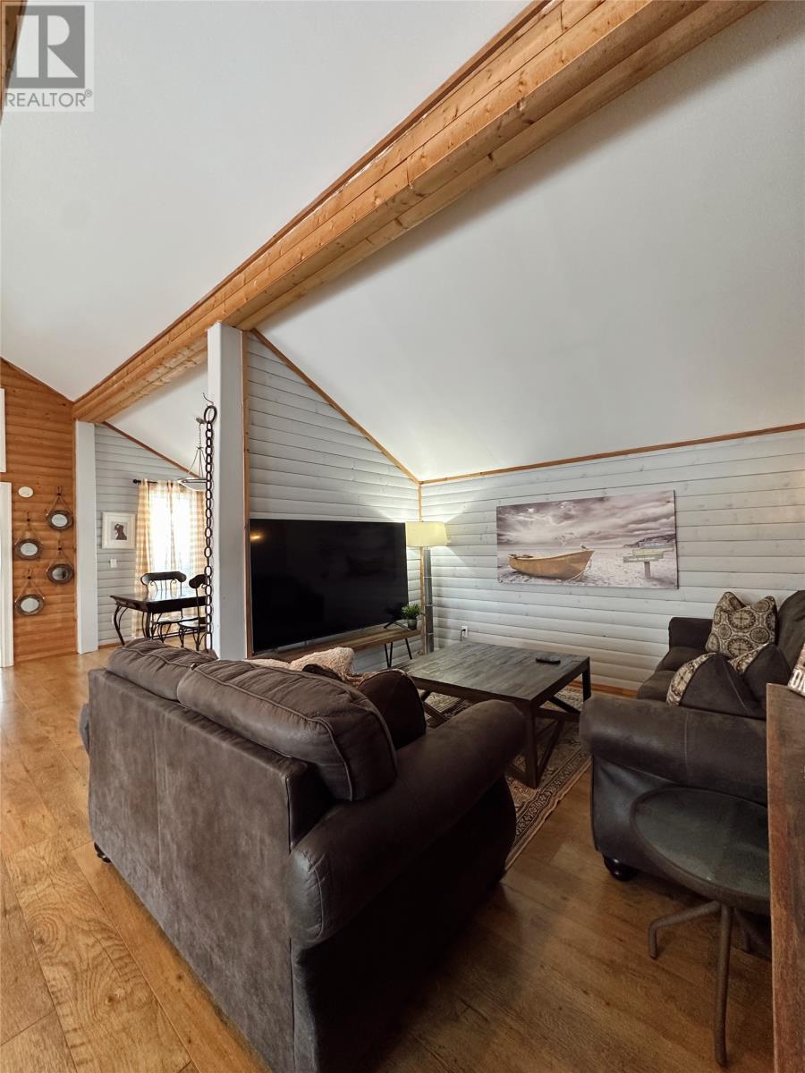 A living room with a brown couch and a television.