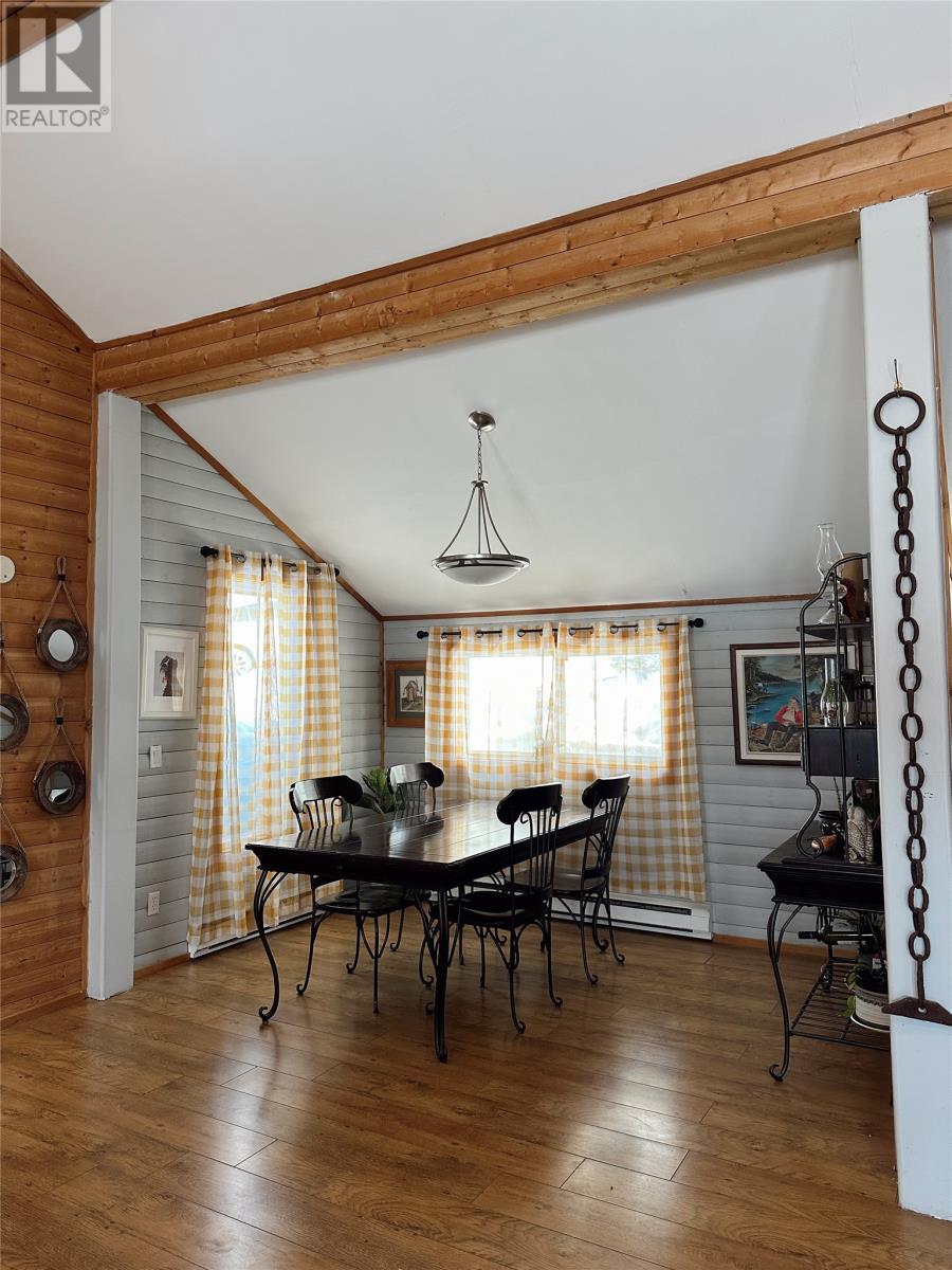 A dining room with a wooden table and chairs.
