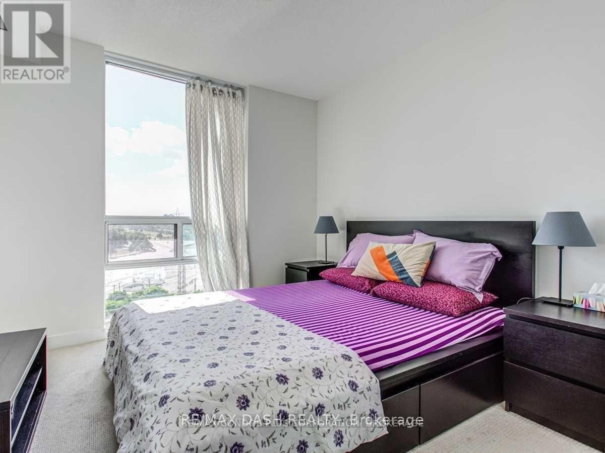 A bedroom with a bed, nightstand, and lamp.