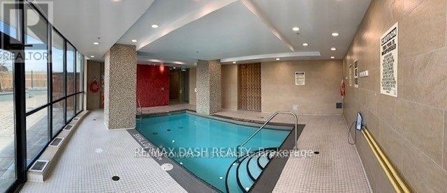A large indoor swimming pool with a tiled floor and walls.