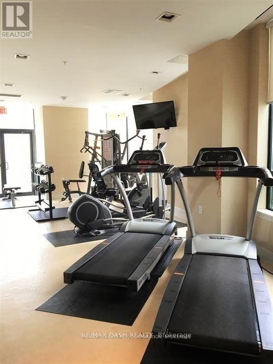 A gym with treadmills, weights and a television.