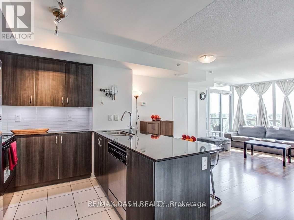 A modern kitchen with dark wood cabinets and a white countertop.