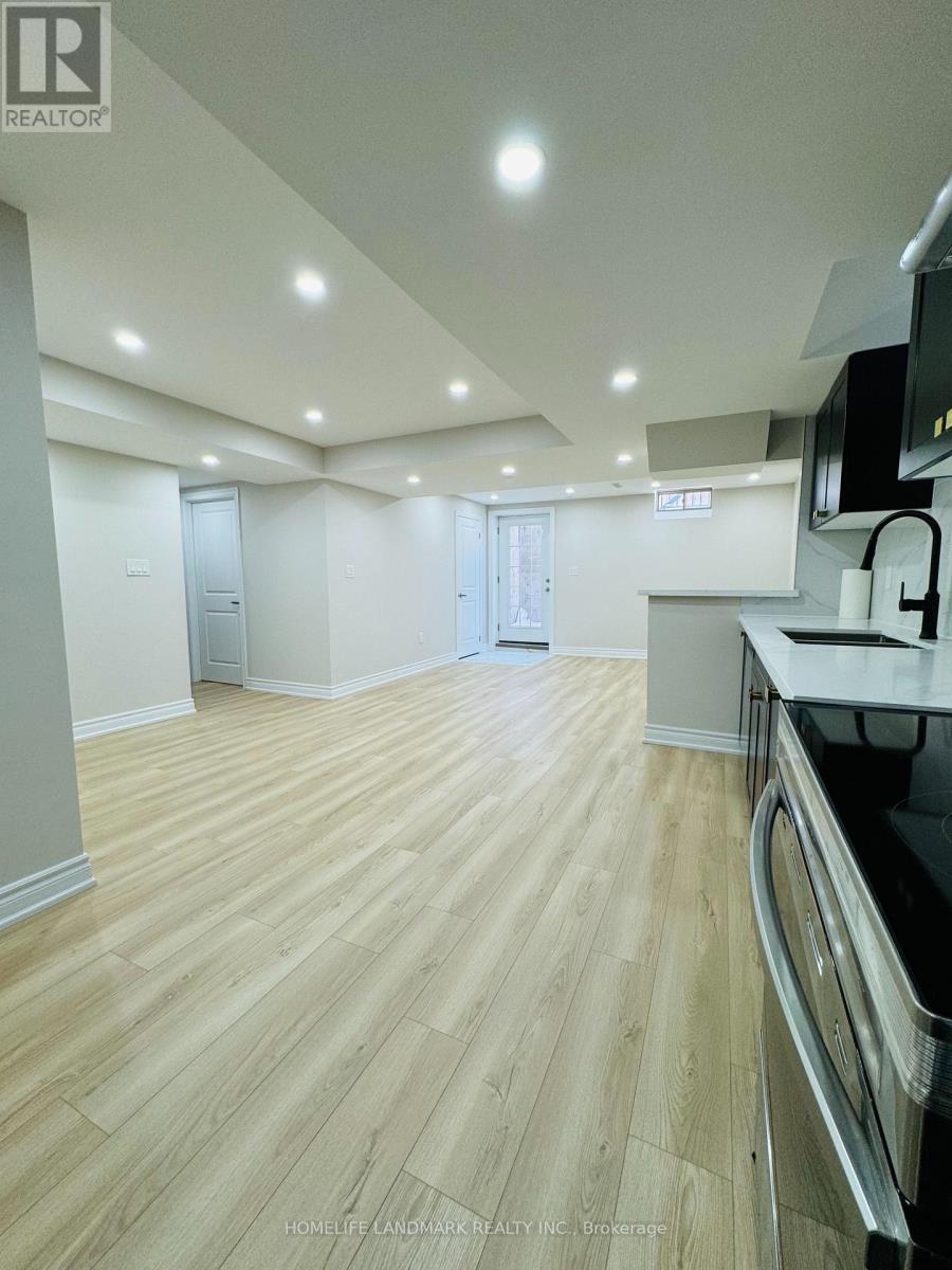 A spacious kitchen with wooden flooring and modern appliances.