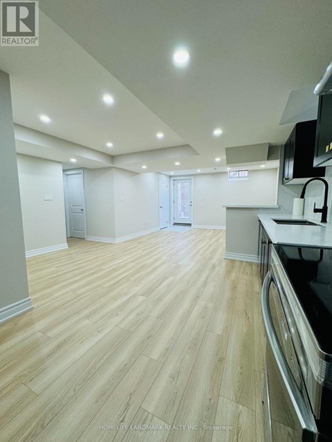 A spacious kitchen with wooden flooring and modern appliances.